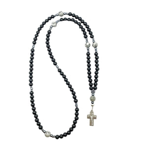 Black rosary necklace on a white background.